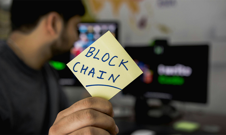 person holding sticky note with blockchain word