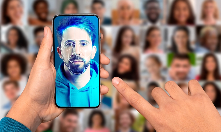 A person uses a smartphone to scan their face for identification. The device displays a digital portrait of the user.