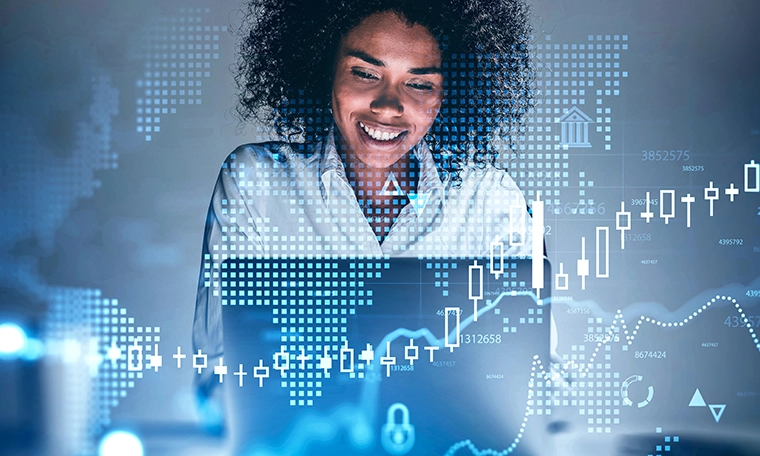 Happy young African American businesswoman using laptop with market and investment graphs overlay,
